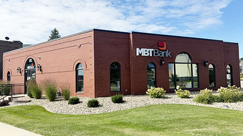 front exterior of a brick building with MBT Bank logo and green grass